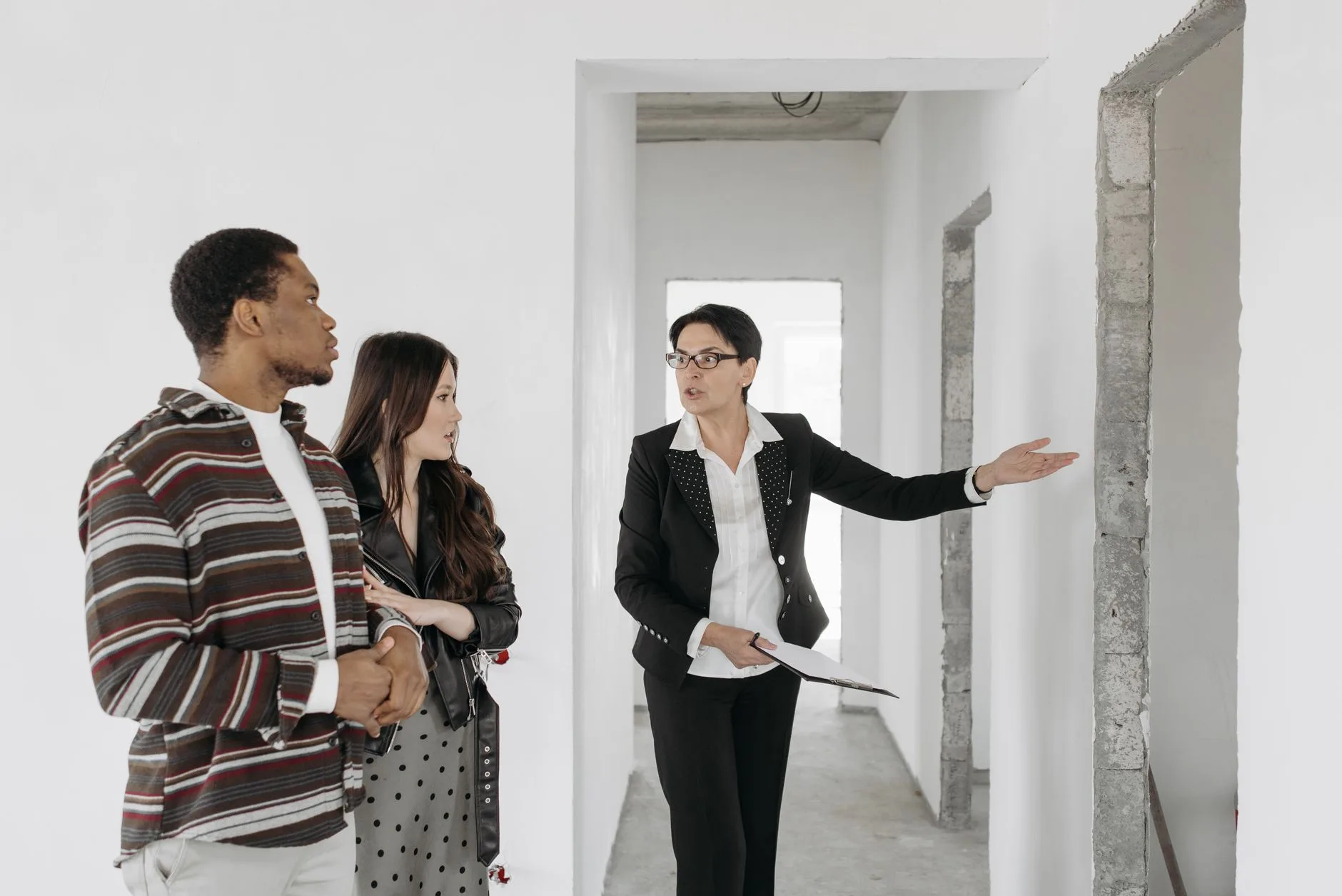 Agent immobilier faisant visiter un appartement à un couple